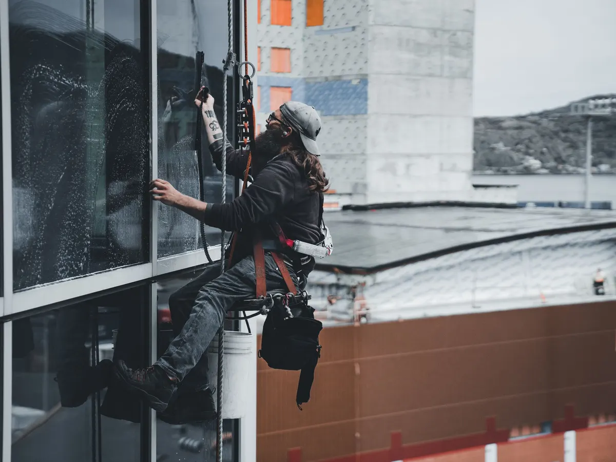 Window cleaners working on a glass building facade